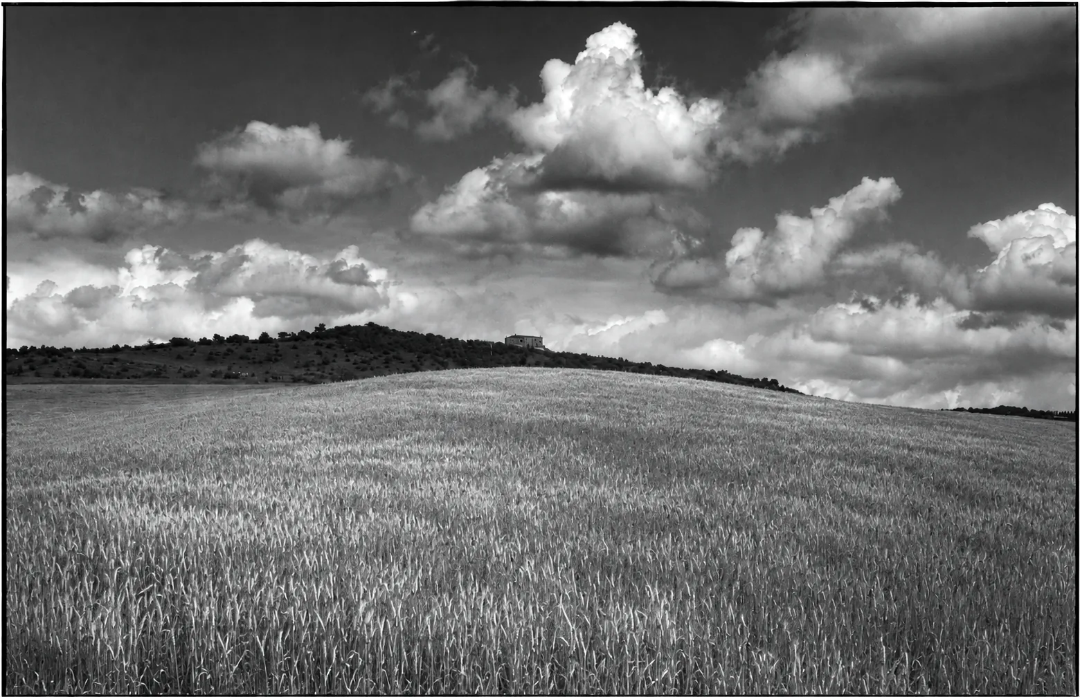 Paesaggio di colline, campo e nuvole
